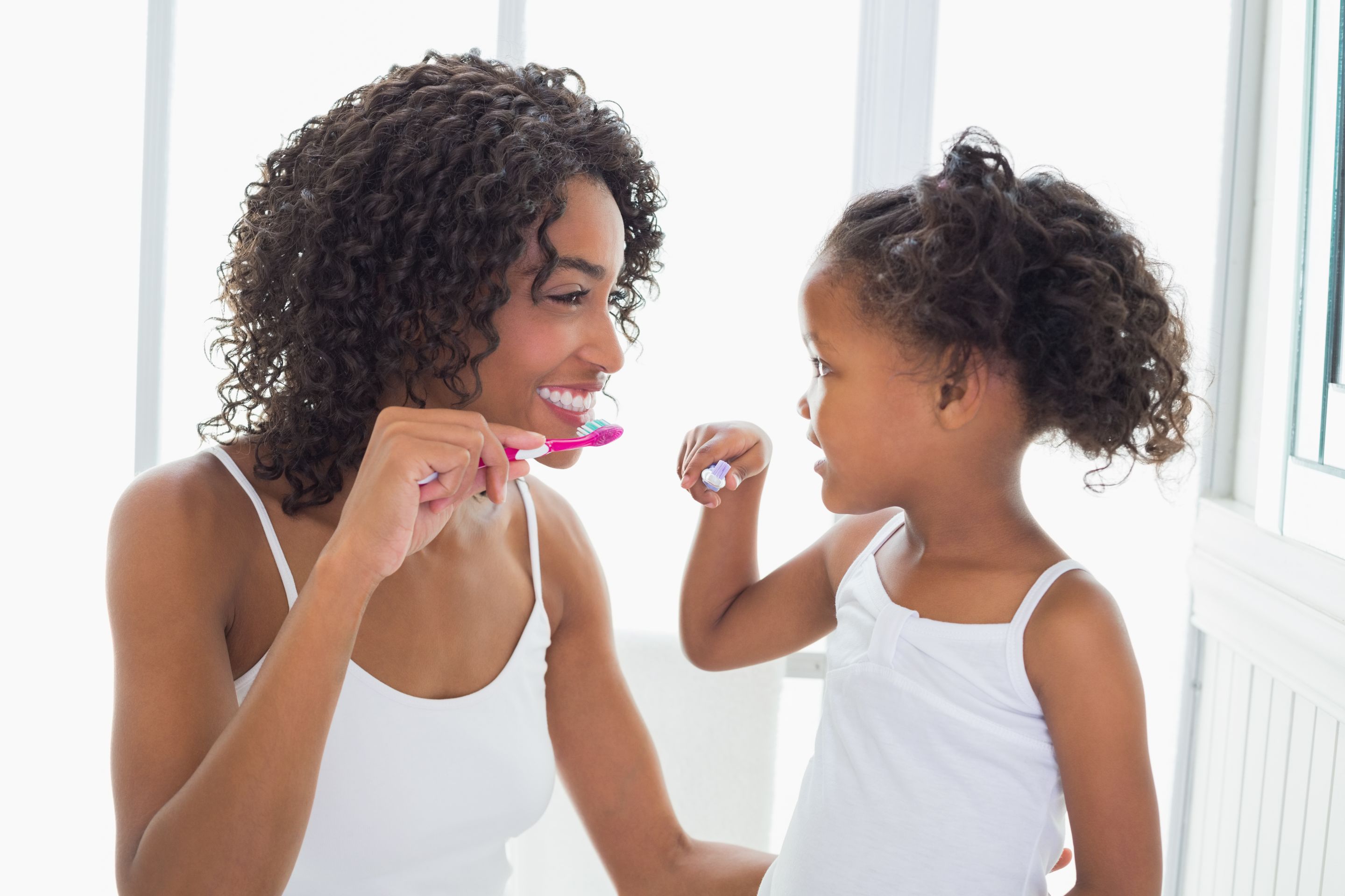 Mother daughter brushing teeth