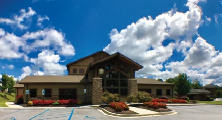 A building with a parking lot and a blue sky. 