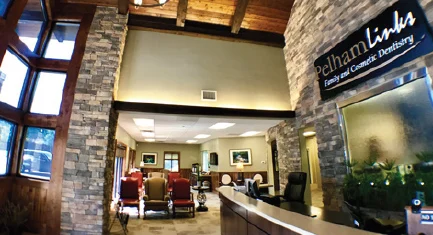 The reception area of a dental office with a stone wall. 