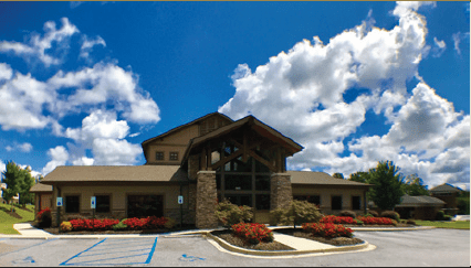 A building with a parking lot and a blue sky. 